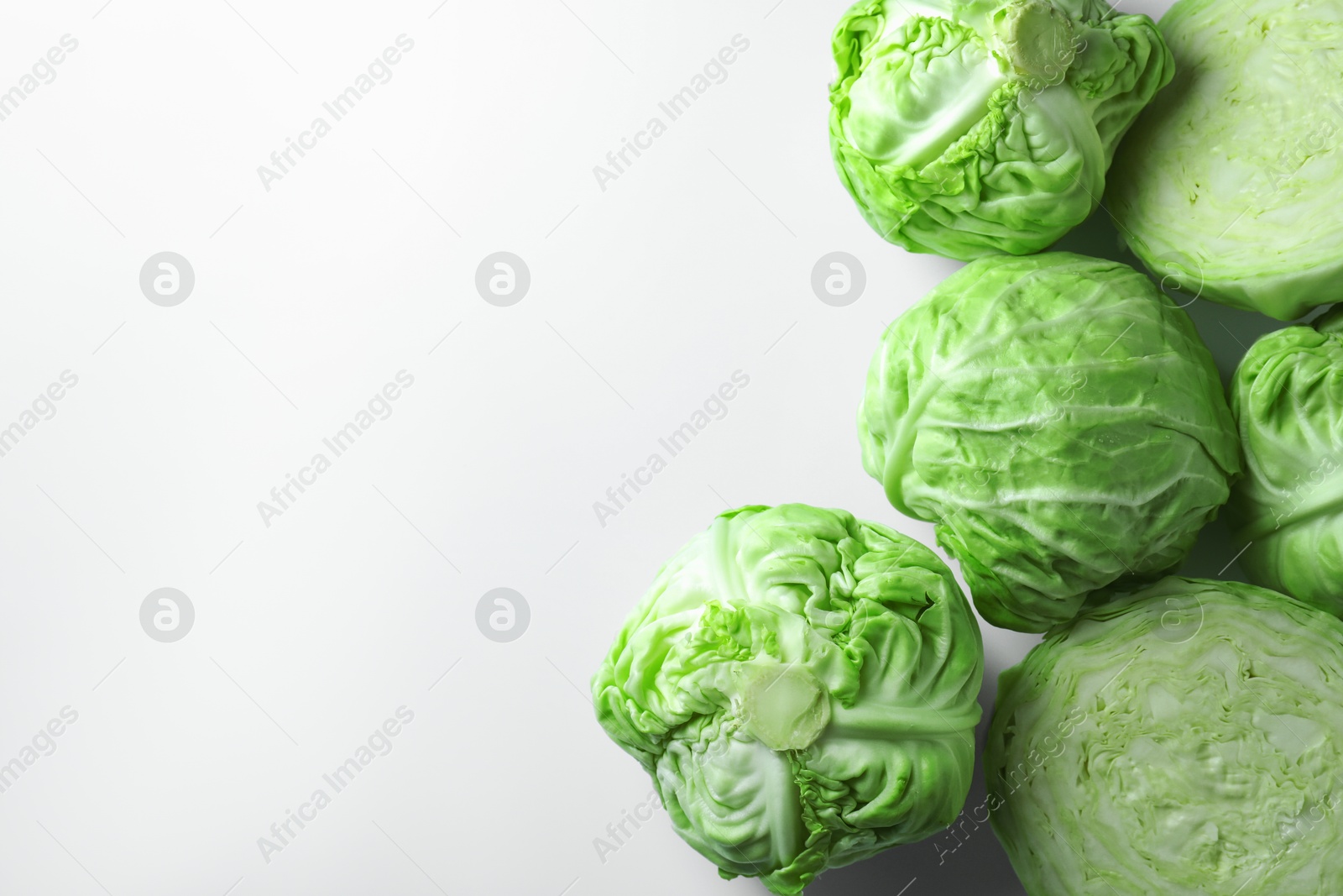 Photo of Raw green cabbages on white background, flat lay. Space for text