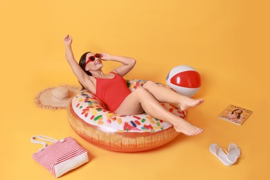 Photo of Beautiful woman in swimsuit with beach accessories on yellow background