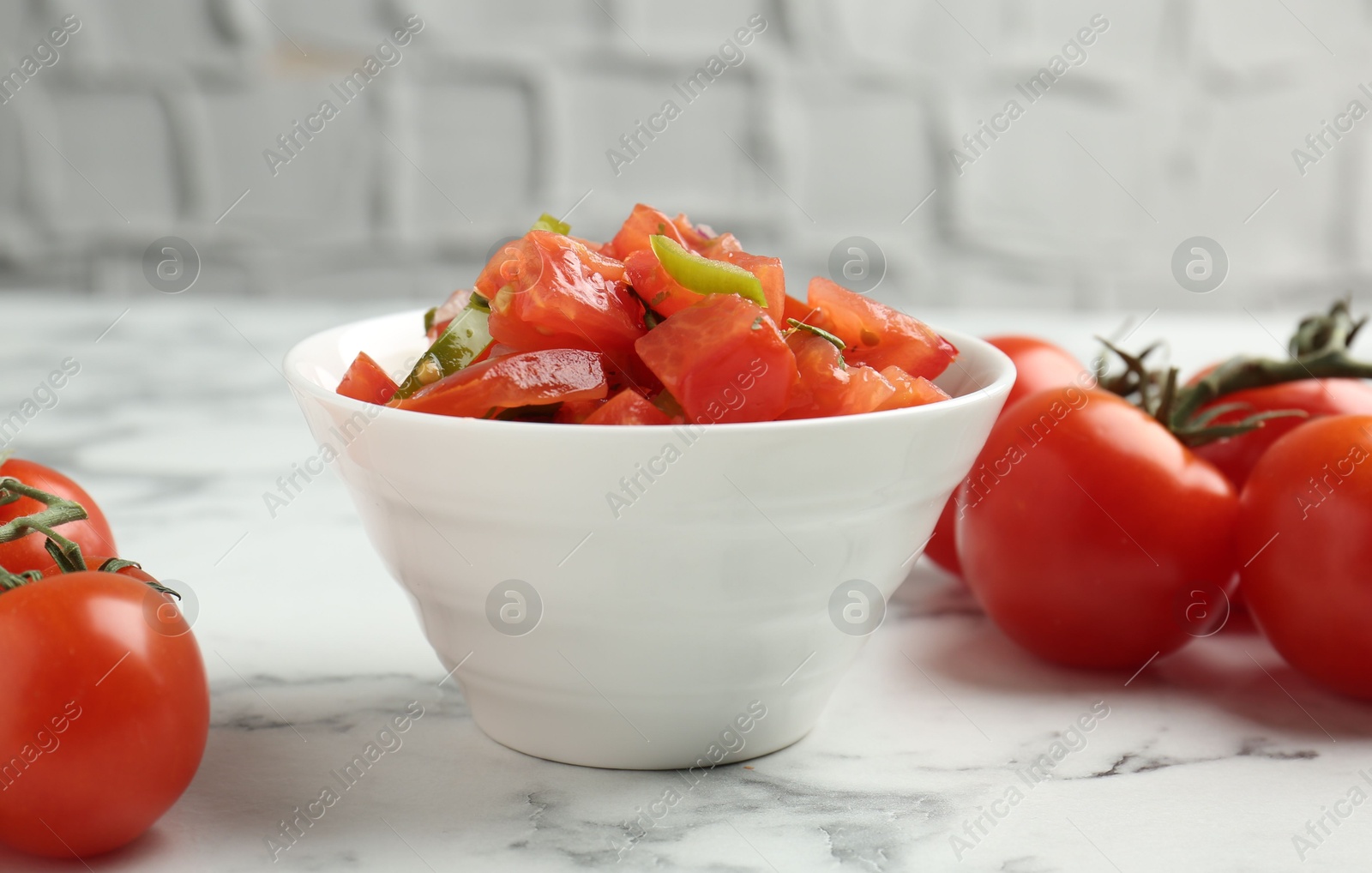 Photo of Delicious salsa and tomatoes on white marble table, closeup