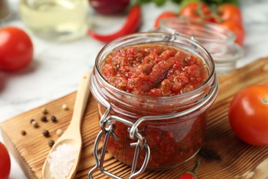 Photo of Spicy salsa and ingredients on table, closeup