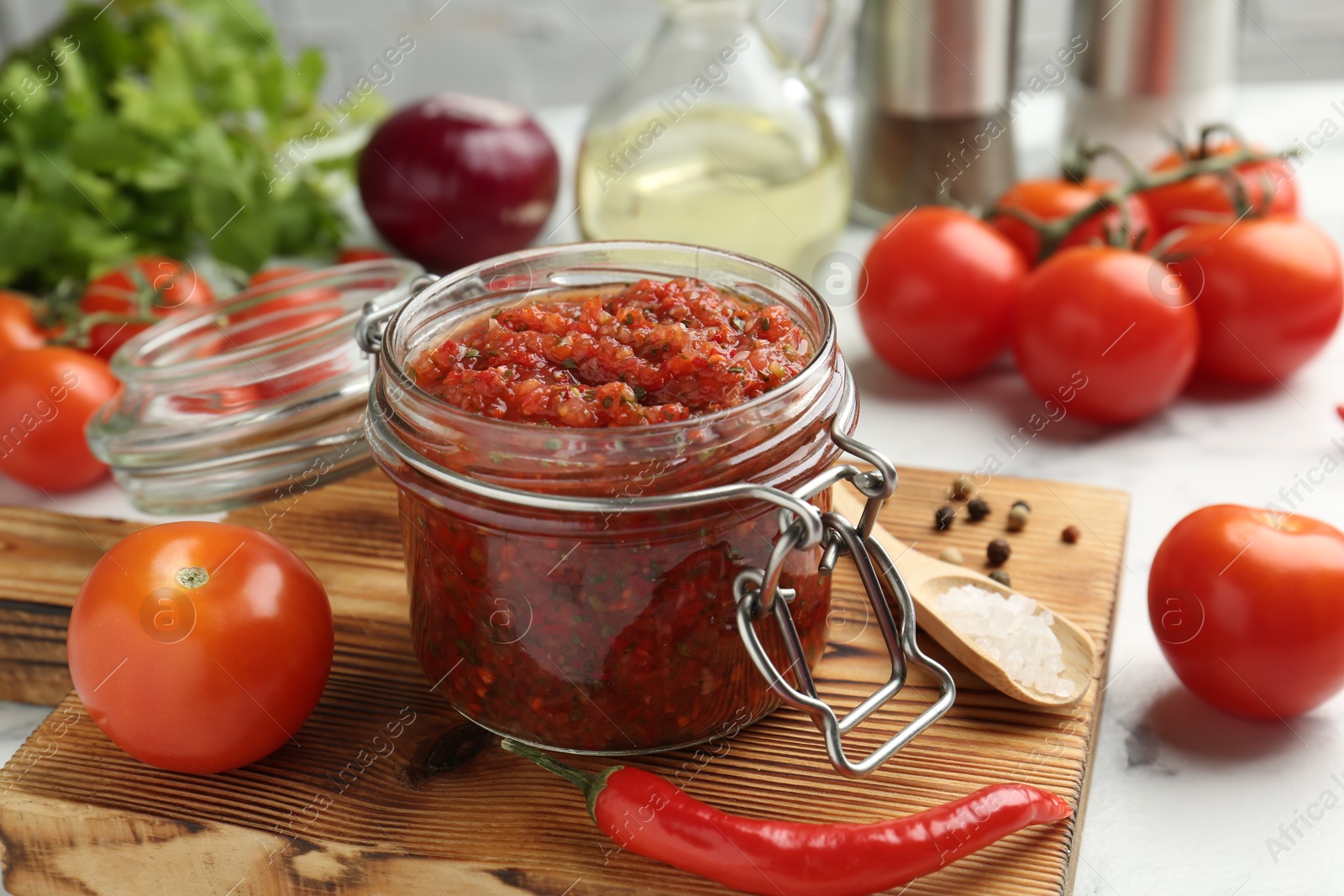 Photo of Spicy salsa and ingredients on table, closeup