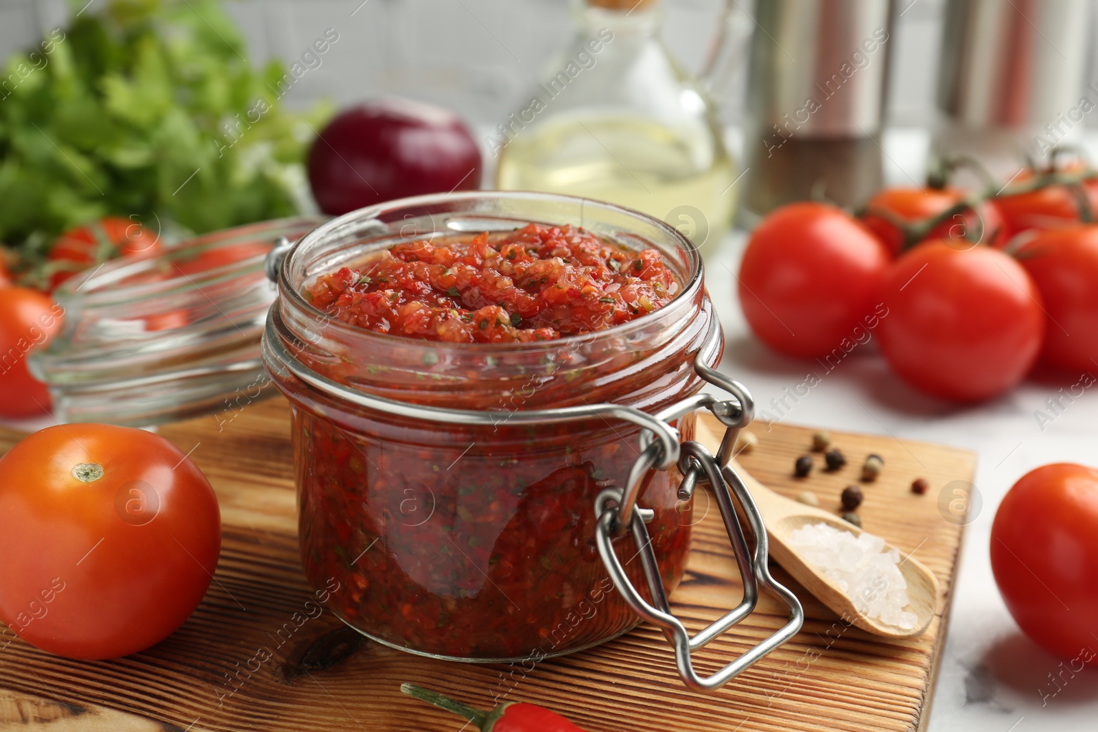 Photo of Spicy salsa and ingredients on table, closeup