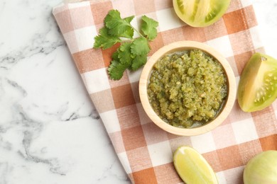 Photo of Spicy salsa and ingredients on white marble table, flat lay