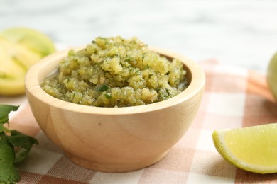 Photo of Spicy salsa and ingredients on table, closeup