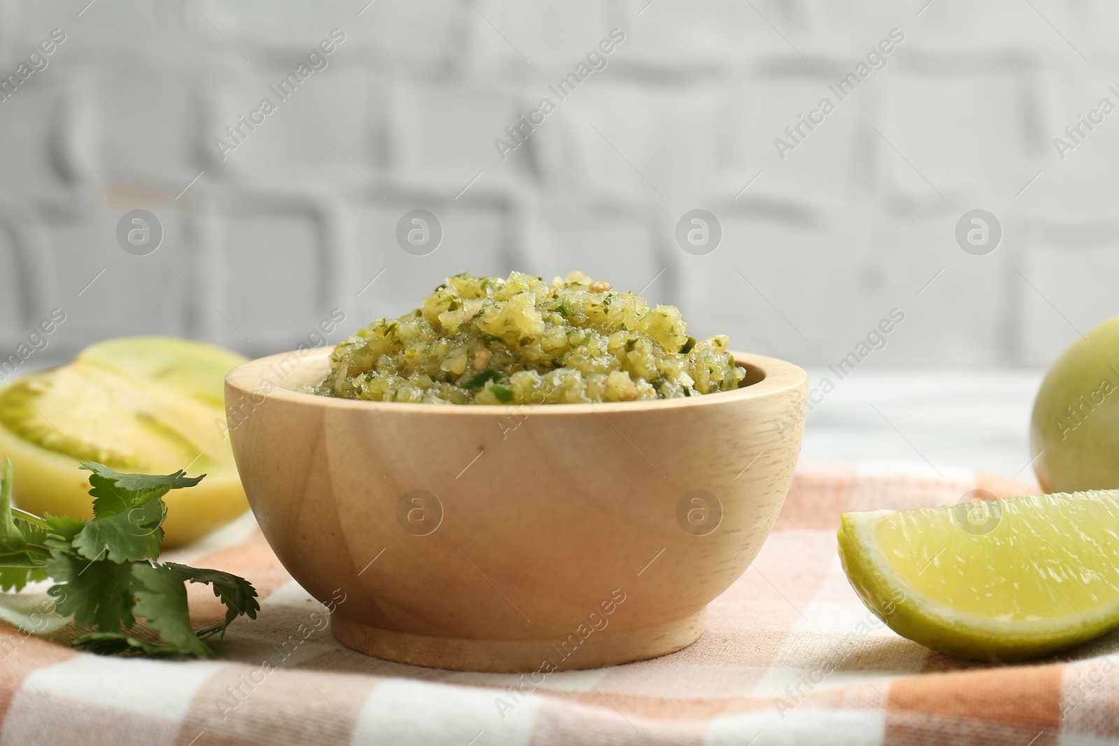 Photo of Spicy salsa and ingredients on table, closeup