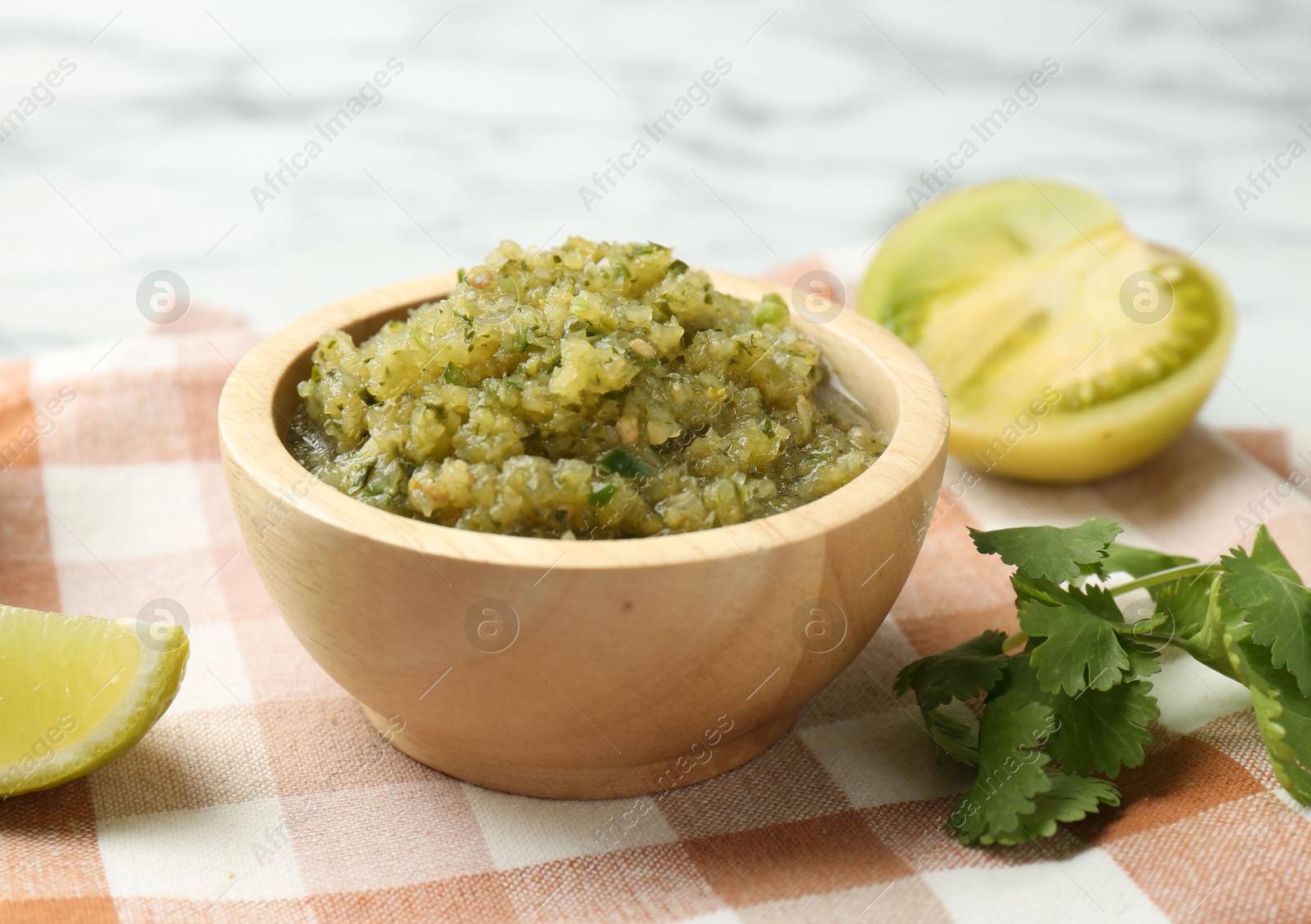 Photo of Spicy salsa and ingredients on table, closeup