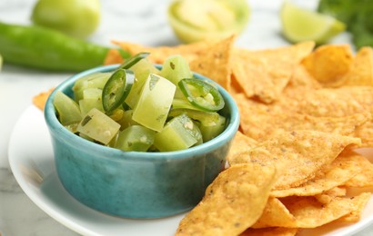 Photo of Delicious salsa with nachos on white table, closeup