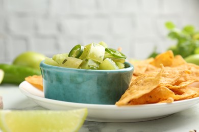 Photo of Delicious salsa with nachos on white table, closeup