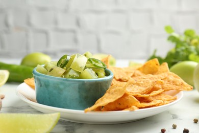 Photo of Delicious salsa with nachos on white table, closeup