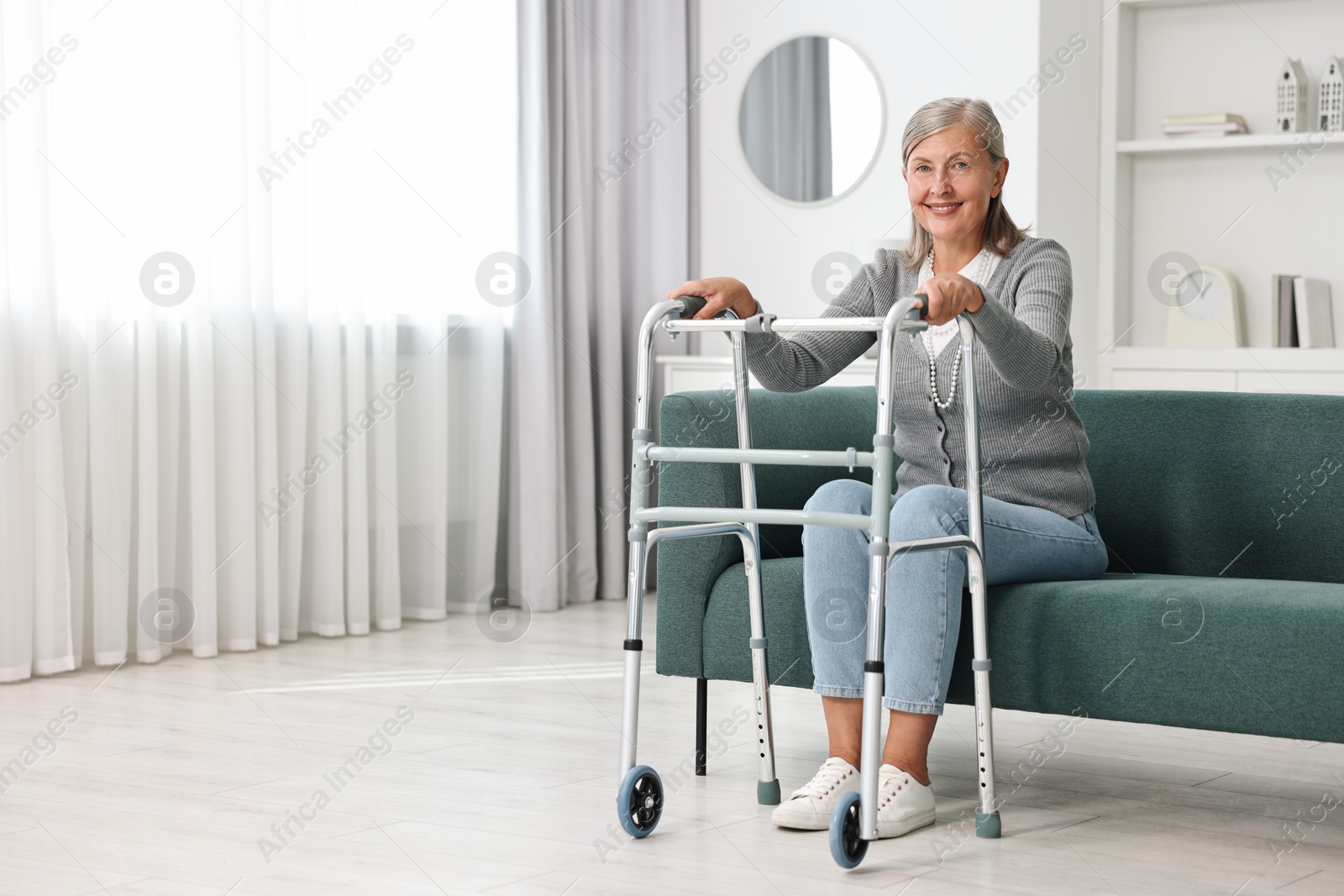 Photo of Senior woman with walking frame on sofa at home, space for text