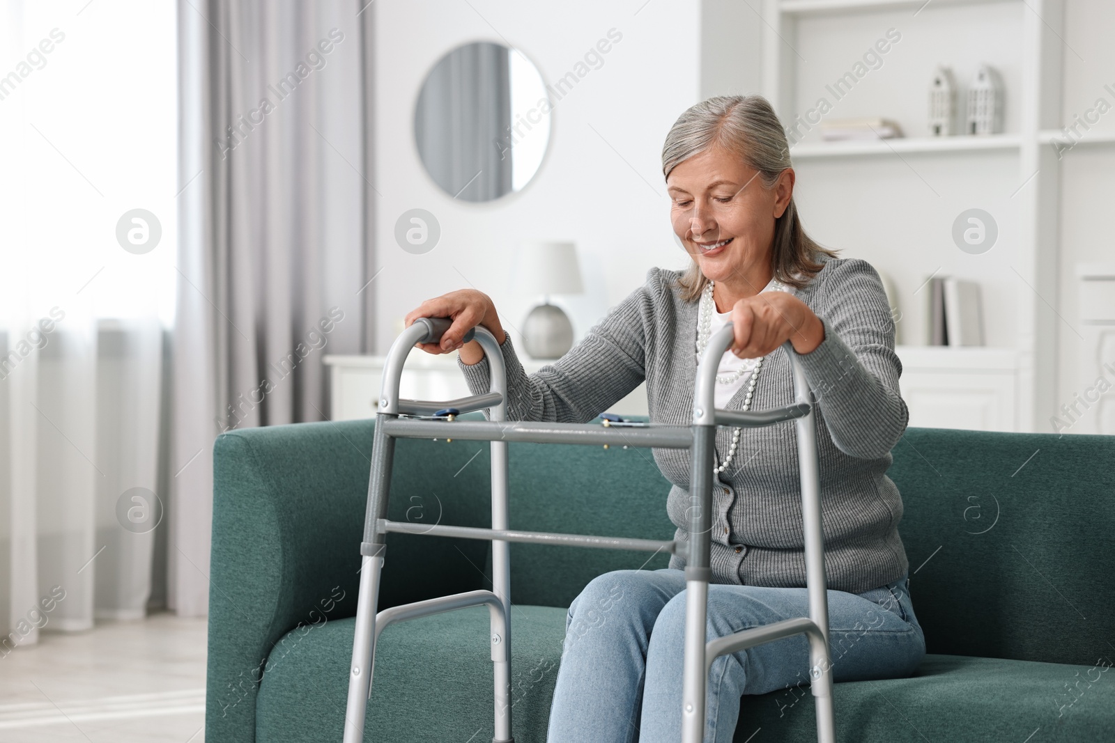 Photo of Senior woman with walking frame on sofa at home