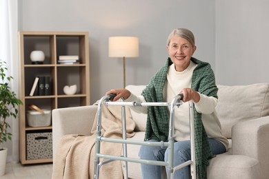 Photo of Senior woman with walking frame on sofa at home