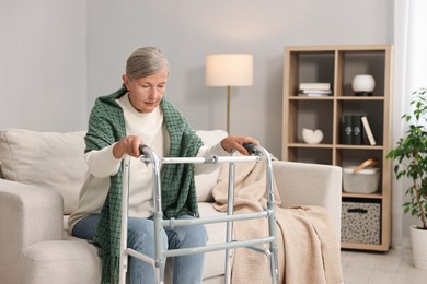 Photo of Senior woman with walking frame on sofa at home