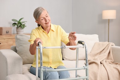 Photo of Senior woman with walking frame on sofa at home