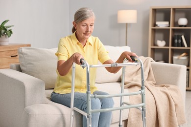 Photo of Senior woman with walking frame on sofa at home