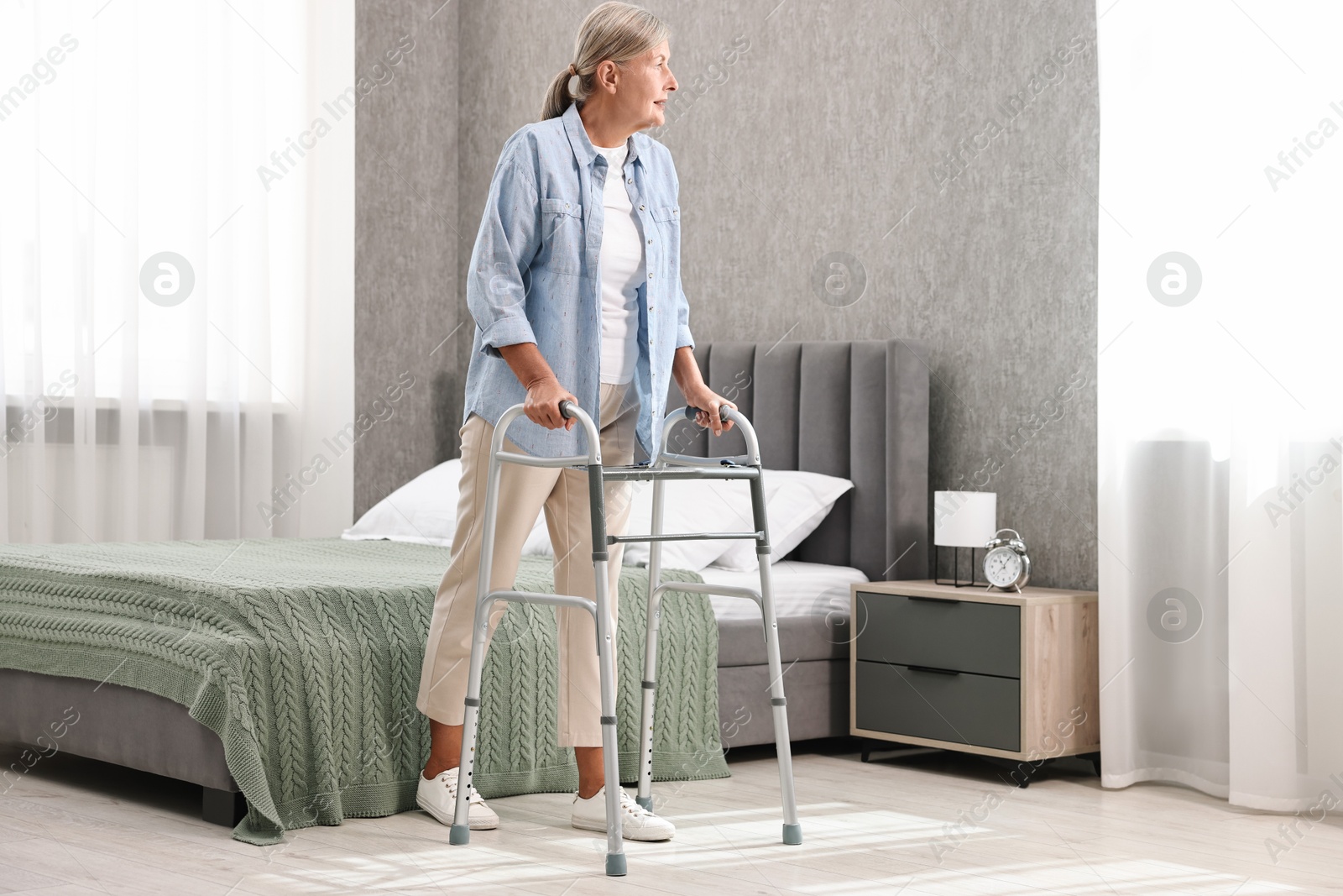 Photo of Senior woman with walking frame at home