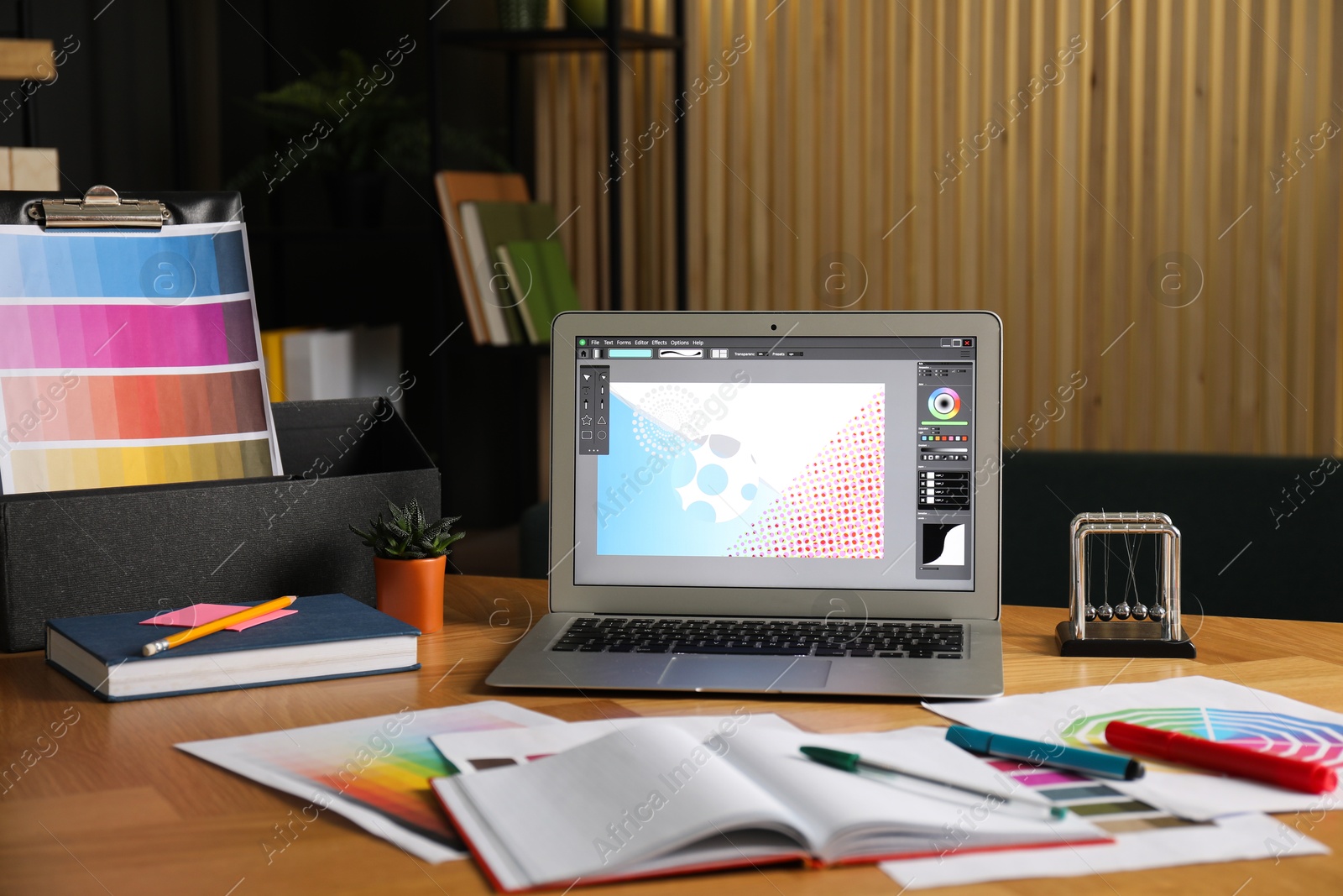 Photo of Designer's workplace with laptop, stationery and palettes on wooden table indoors