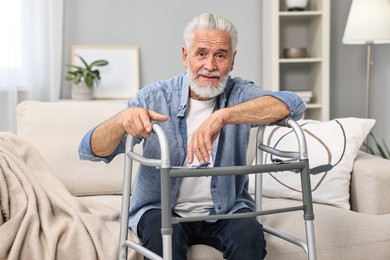 Photo of Senior man with walking frame on sofa at home