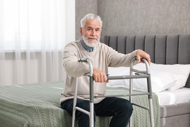 Photo of Senior man with walking frame on bed at home