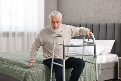 Photo of Senior man with walking frame on bed at home