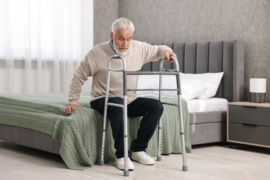 Photo of Senior man with walking frame on bed at home