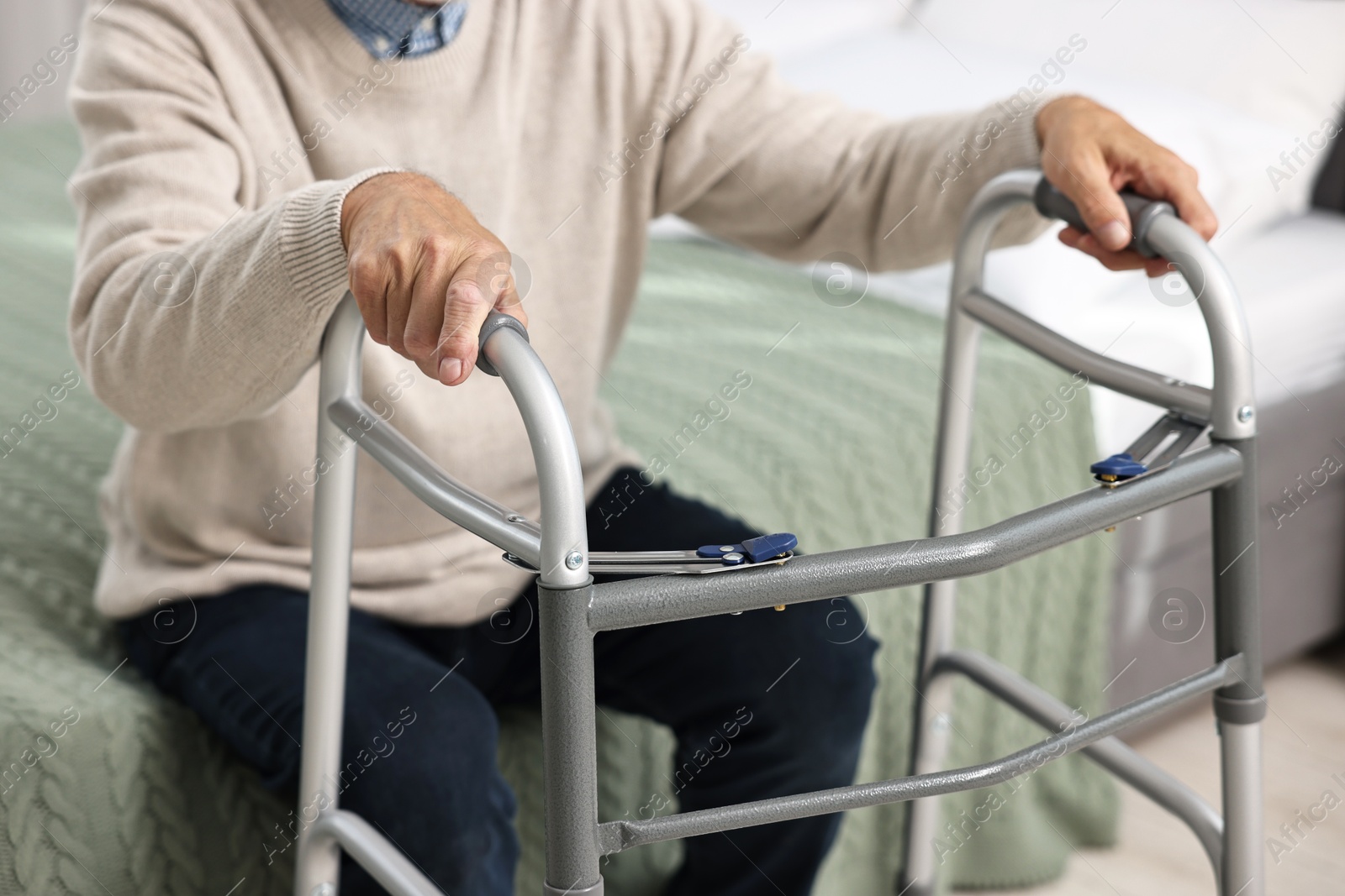 Photo of Senior man with walking frame on bed at home, closeup