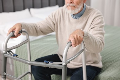 Photo of Senior man with walking frame on bed at home, closeup