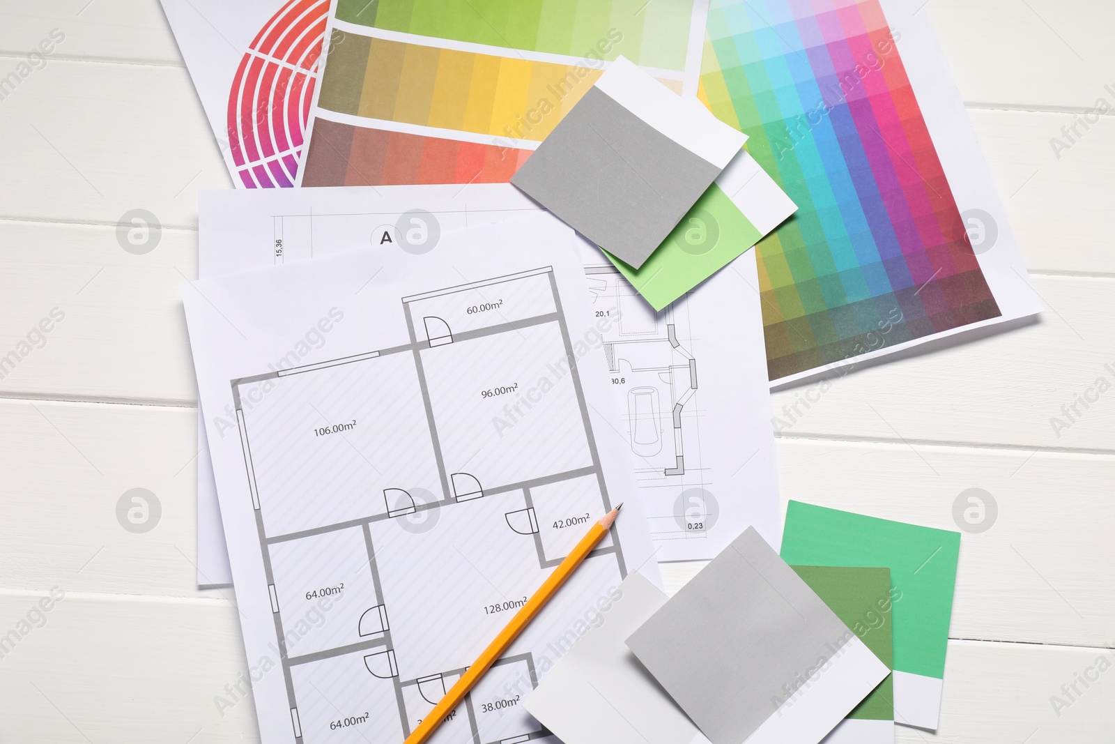 Photo of Designer's workplace with color palettes, floor plans and pencil on white wooden table, flat lay