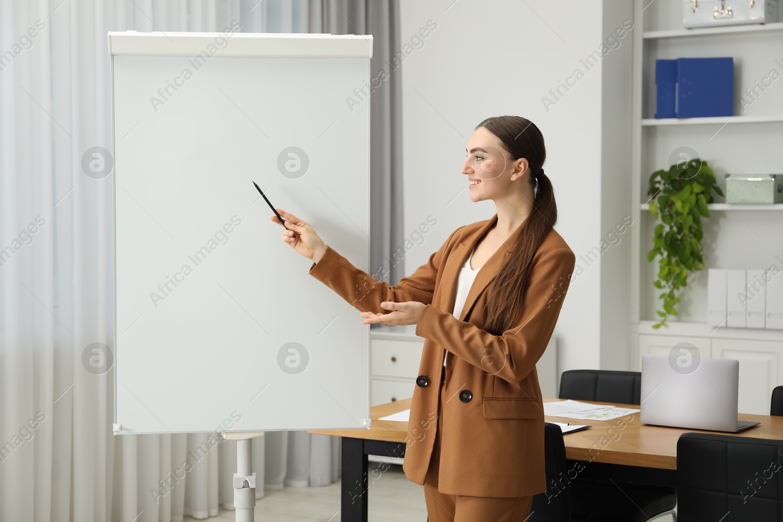 Photo of Happy woman near flip chart in office. Mockup for design