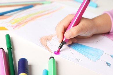 Photo of Little girl drawing his family at white table, closeup