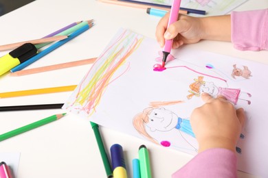 Photo of Little girl drawing his family at white table, closeup