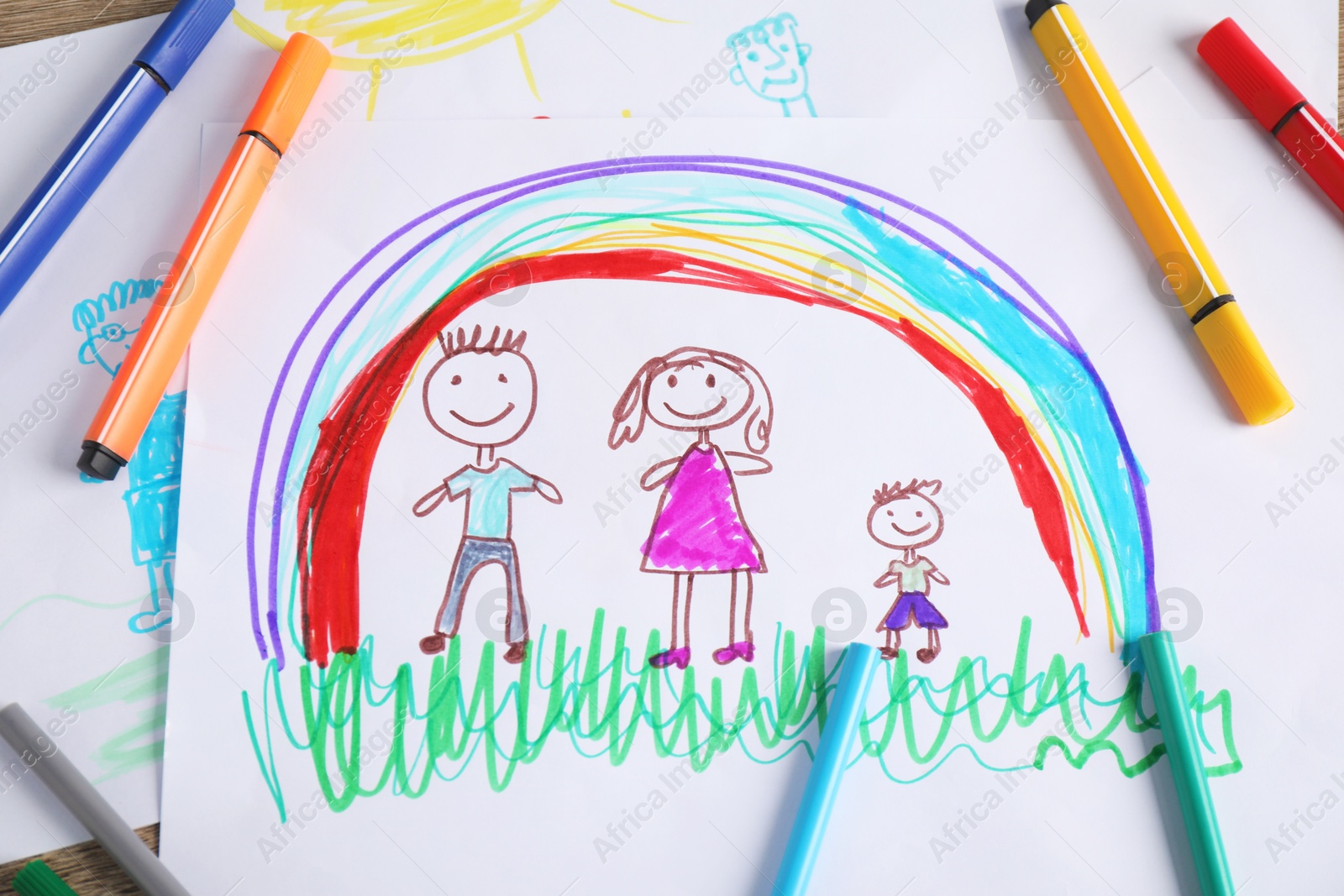 Photo of Child's drawing of happy family and felt tip pens as background, top view