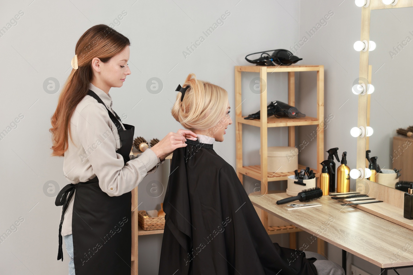 Photo of Hair cutting. Professional hairdresser working with client in salon