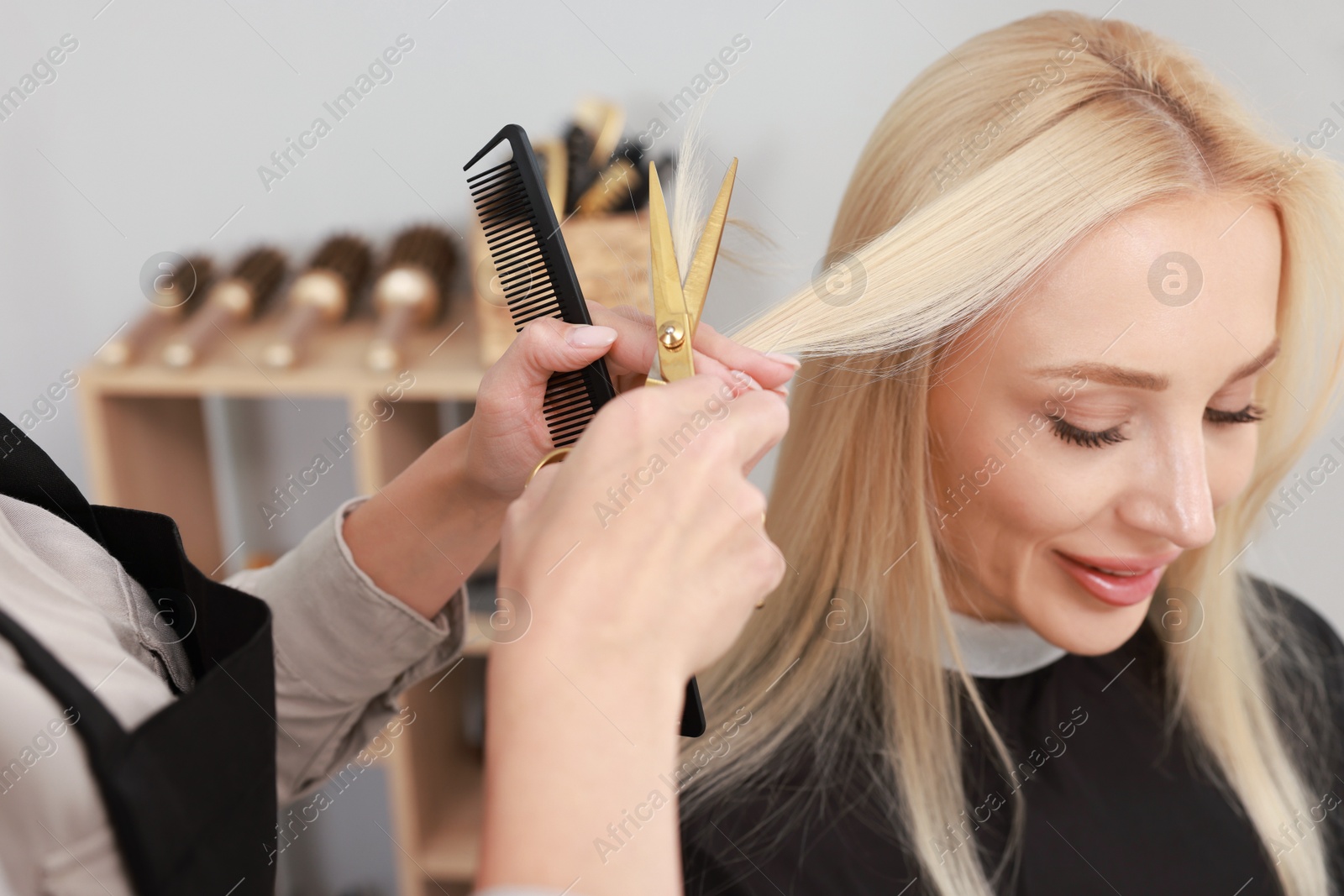 Photo of Hair cutting. Professional hairdresser working with client in salon, closeup