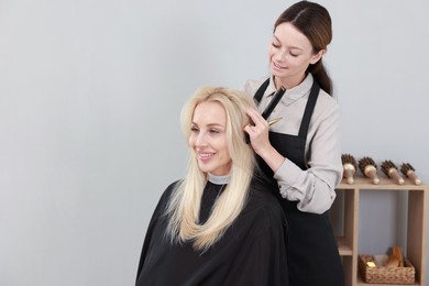 Photo of Hair cutting. Professional hairdresser working with client in salon