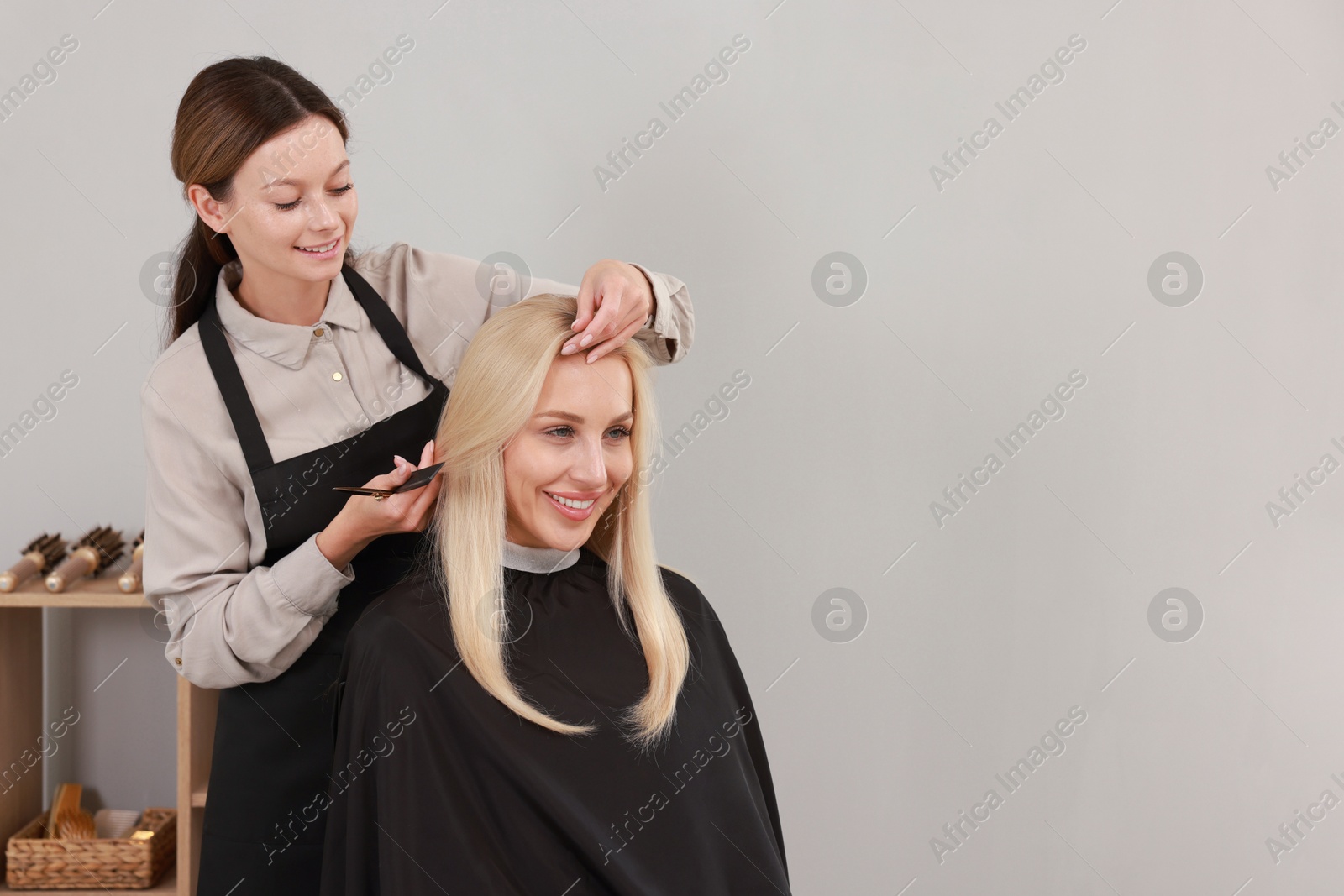 Photo of Hair cutting. Professional hairdresser working with client in salon, space for text