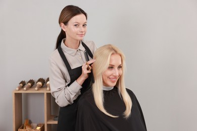 Photo of Hair cutting. Professional hairdresser working with client in salon