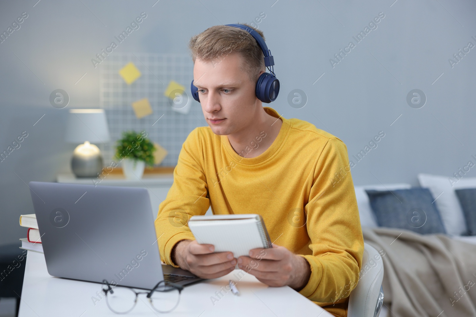 Photo of Student preparing for exam with laptop at table indoors