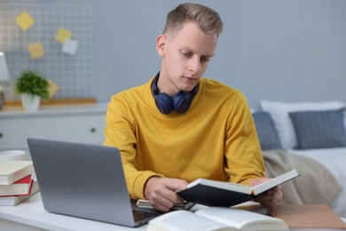 Photo of Student preparing for exam at table indoors