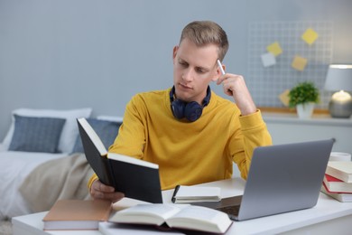 Photo of Student preparing for exam at table indoors