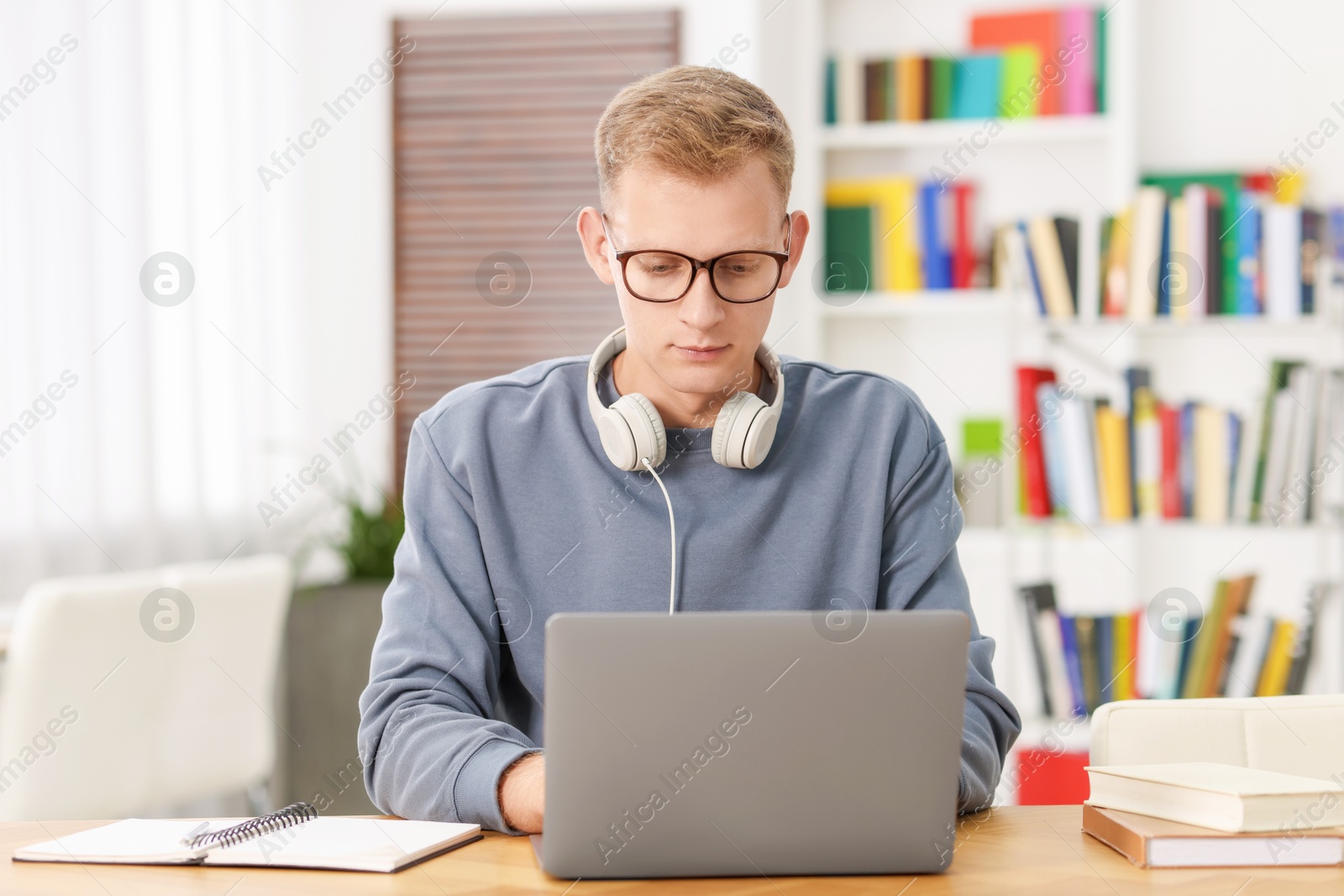 Photo of Student preparing for exam with laptop at table indoors