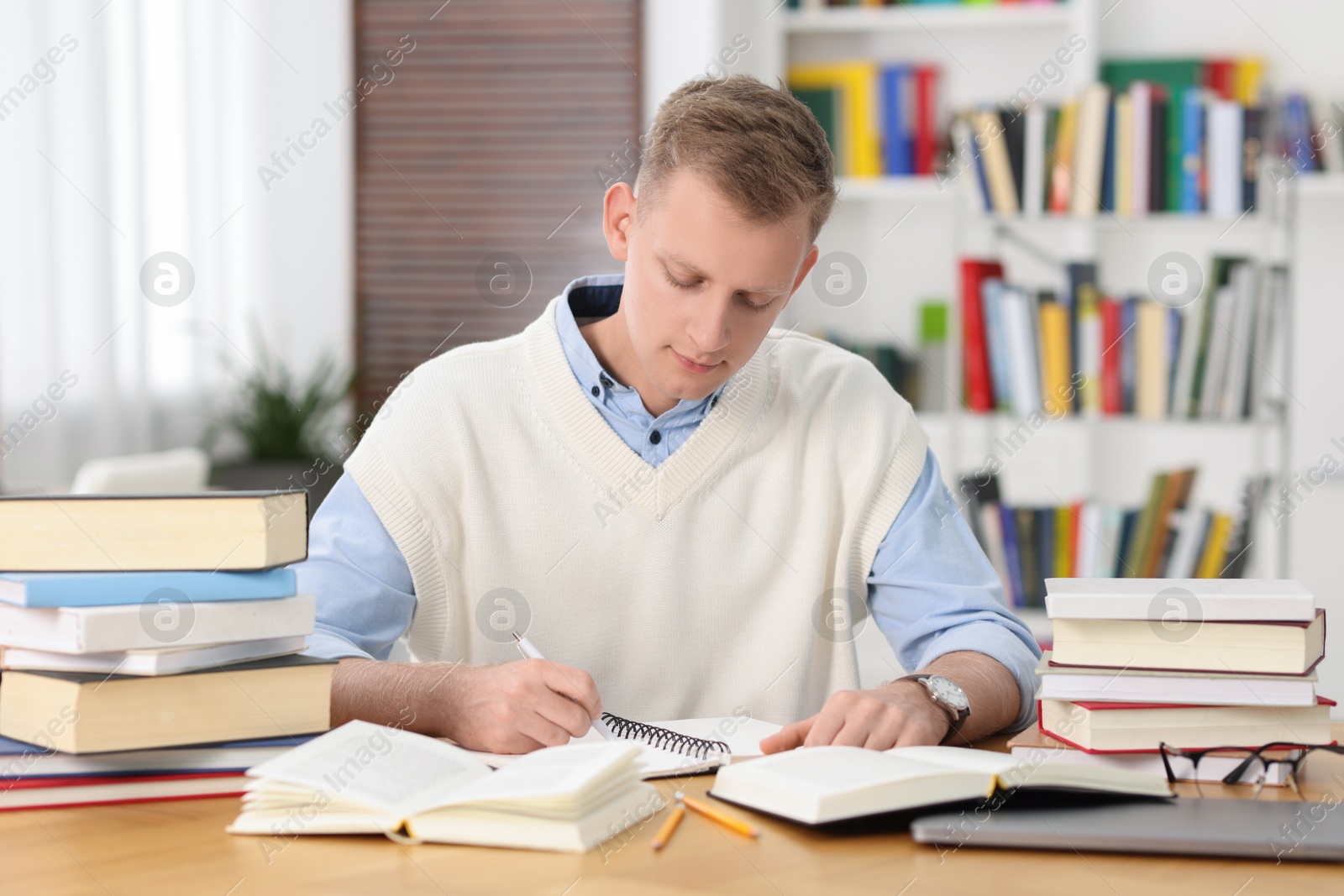 Photo of Student preparing for exam at table indoors