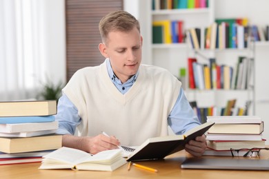 Student preparing for exam at table indoors