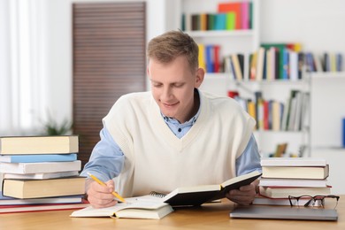 Photo of Student preparing for exam at table indoors