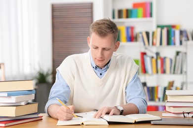 Photo of Student preparing for exam at table indoors