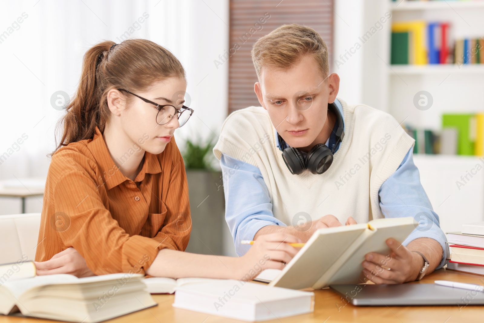 Photo of Students preparing for exam at table indoors