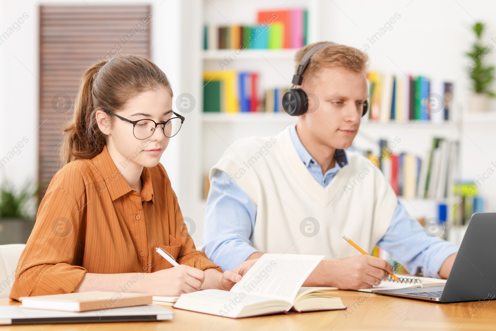 Photo of Students preparing for exam at table indoors