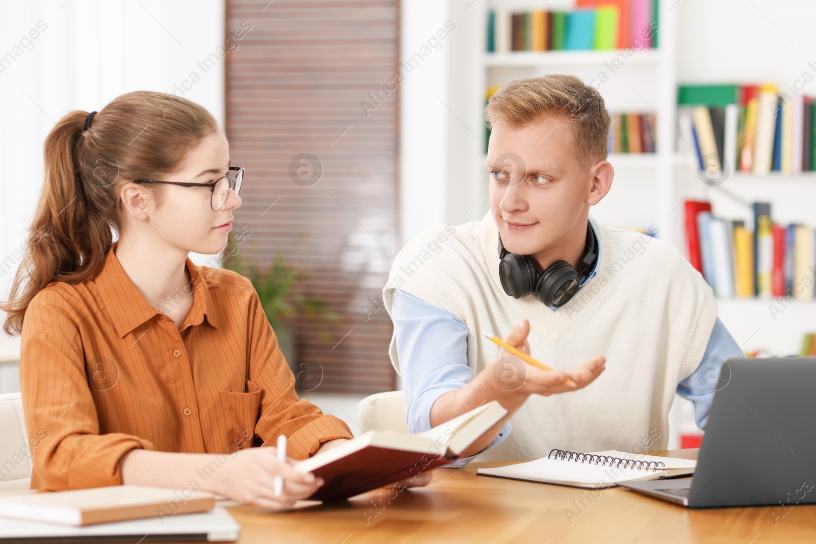 Photo of Students preparing for exam at table indoors