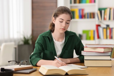 Photo of Student preparing for exam at table indoors