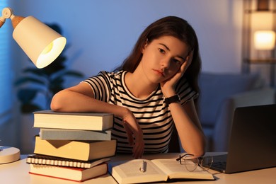 Photo of Preparing for exam. Student with books at table indoors